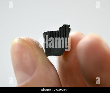 A man holds in his hand an object crown printed on a 3d printer that prints metal close-up Stock Photo