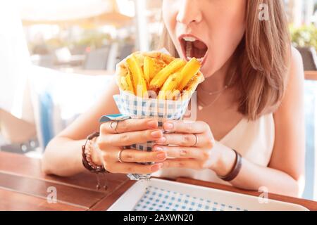 girl in street food cafe eats tasty and juicy gyros with pita. Middle Eastern cuisine concept Stock Photo