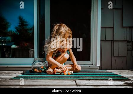4 year old girl playing with rubber ball on a summer day