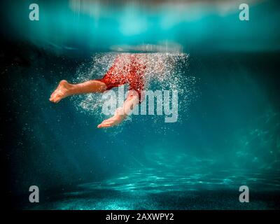 Underwater picture of a boy swimming in a pool Stock Photo