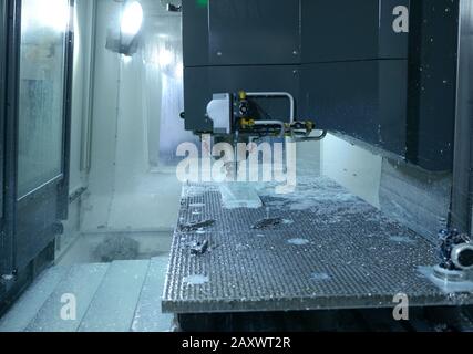 Computer numerical control milling machine set for work, drill boring hole in a metal piece, close up Stock Photo