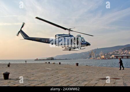 Trieste, Italy - September 27, 2009: Italian police helicopter with diver on the tailgate, during takeoff from the port dock. Stock Photo