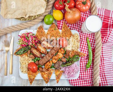 Turkish and Arabic Traditional Ramadan Mix Kebab Plate inside Adana, Urfa, Chicken, Lamb, Liver and Beef on bread and lahmacun. Stock Photo