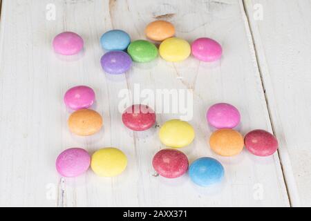 Lot of whole sweet colourful candy on white wood Stock Photo