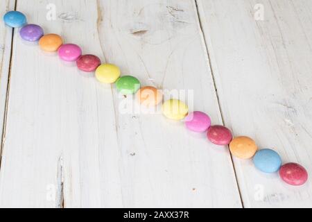 Lot of whole sweet colourful candy on white wood Stock Photo