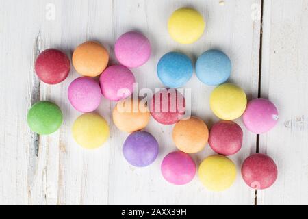 Lot of whole sweet colourful candy flatlay on white wood Stock Photo