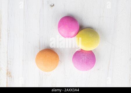 Group of four whole sweet colourful candy flatlay on white wood Stock Photo