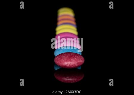 Lot of whole sweet colourful candy isolated on black glass Stock Photo