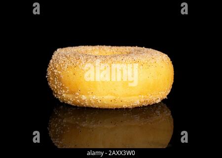 One whole sweet golden mini cinnamon donut isolated on black glass Stock Photo