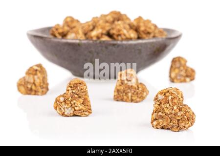 Lot of whole healthy brown cereal heart with cocoa in dark ceramic bowl isolated on white background Stock Photo