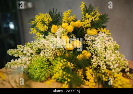 Male make spring bouquet. Gardener's in the flower shop make bouquet. Lifestyle flower shop. Beautiful flower composition of yellow flowers Stock Photo