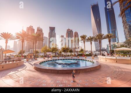 29 November 2019, UAE, Dubai: People walk and relax on the promenade in Dubai Marina. Stock Photo