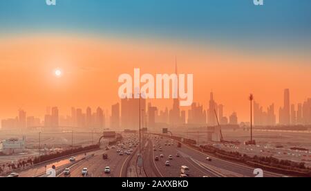 Highway Road and Dubai cityscape skyline at sunset. Transportation and travel in UAE concept Stock Photo