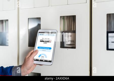 Male Technician Doing Meter Reading Using Tablet Stock Photo