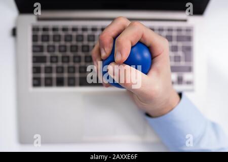Close-up Of Businessman Holding Stress Ball In Hand Stock Photo