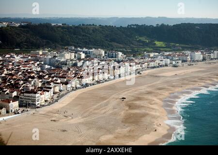 The beach in front of Nazare is wide. There is plenty of room, especially during low season. Praia overlooking from Sitio. Stock Photo