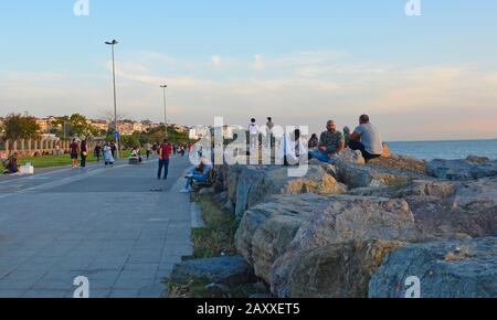 Istanbul, Turkey - September 16th 2019. People relax in the late afternoon sun on the waterfront in the Moda district of Kadikoy on Istanbul's Asian s Stock Photo