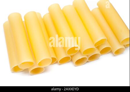 Close up of a stack of dried cannelloni pasta, a tubular pasta that is stuffed with meat or vegetables, on a white background Stock Photo
