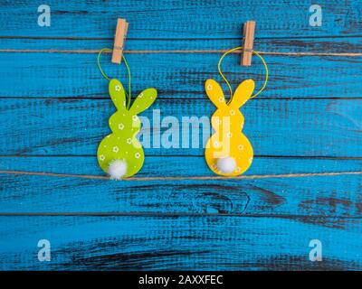 easter holidays concept, green and yellow bunny toy on trendy blue wooden background Stock Photo