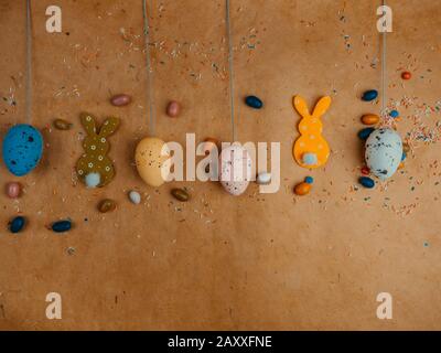 Toy cute bunny and colorful easter eggs, delicious candies on yellow background. bunny. Funny decoration. Happy Easter concept Stock Photo