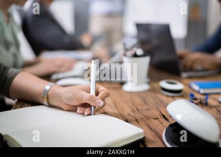 Group Of Business Executives Taking Notes During A Meeting At Office Stock Photo