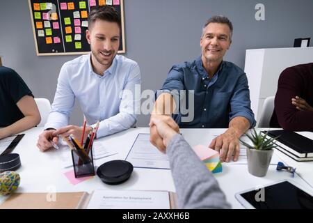 First Person View Of Woman Shaking Hands After Finishing Up A Meeting In Office Stock Photo