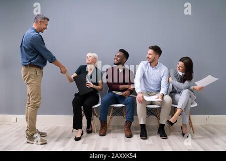 Smiling Young Businessman Shaking Hands With Female Candidate In Office Stock Photo
