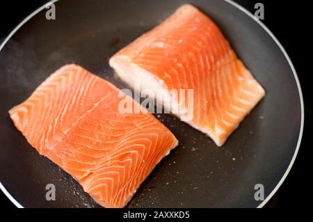 Overhead view of two raw salmon fillets in a pan waiting to be pan seared or fried for a delicious seafood meal Stock Photo