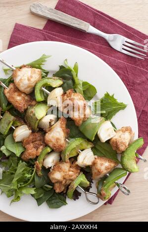chicken satay shish kebabs on a bed of salad leaves with onion and bell pepper Stock Photo
