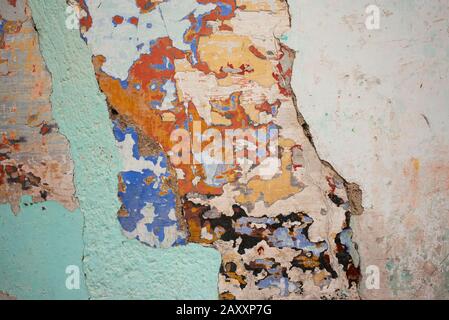 Multi-coloured wall texture with various layers of paint showing. Old grunge painted surface background Stock Photo