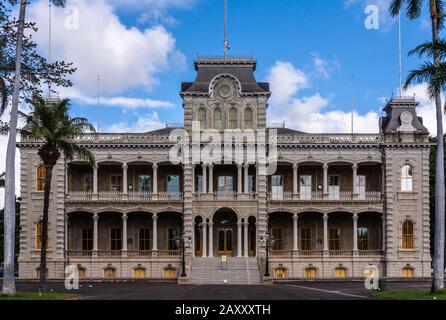 Honolulu  Oahu, Hawaii, USA. - January 10, 2012: Closeup of full frontal gray with pillars facade of Iolani Palace under blue cloudscape with palm tre Stock Photo