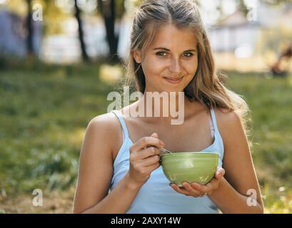 Portrait of happy smiling young woman eating noodles Stock Photo