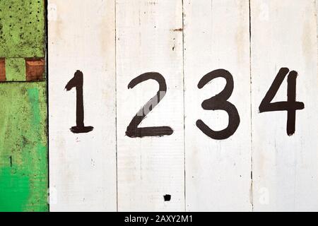 The entrance of a shop is closed with white and green painted wooden panels, which are marked with big numbers, often seen in the Philippines, Asia Stock Photo