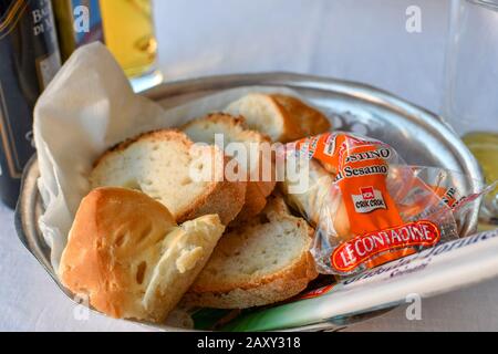 A typical basket of bread and rolls brought to the table at an Italian restaurant. Stock Photo