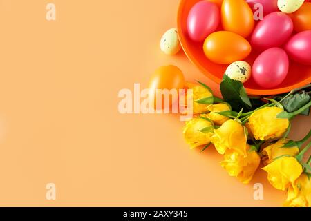 Colorful Eater eggs with yellow roses on light background Stock Photo