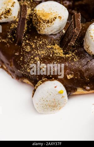 Tight close up of chocolate glazed doughnut with marshmallow toppings Stock Photo