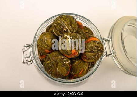 A ball of flower tea in a glass jar on a white background. Close up Stock Photo
