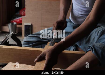 Carpenter working with gouge on table in his workshop Stock Photo