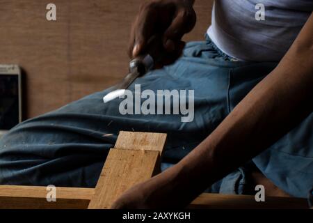 Carpenter working with gouge on table in his workshop Stock Photo