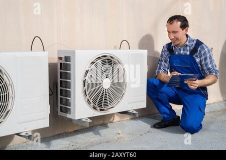 Man Doing Heating, Ventilation, And Air Conditioning Inspection Stock Photo