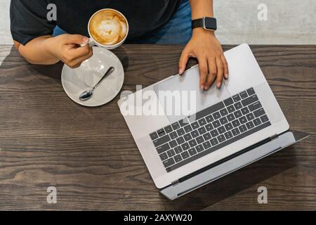 Top view photo of human hand using laptop at coffeeshop Stock Photo