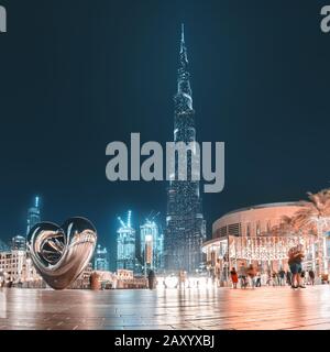 28 November 2019, UAE, Dubai: Panoramic view of illuminated Burj Khalifa building at evening. I love Dubai caption with iron heart Stock Photo