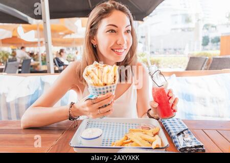 girl in street food cafe eats tasty and juicy gyros with pita. Middle Eastern cuisine concept Stock Photo