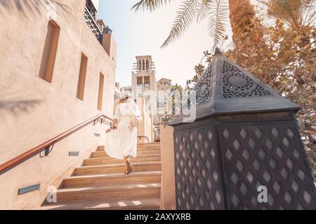 Happy Asian tourist girl walks through the old Arab city in Dubai, United Arab Emirates Stock Photo