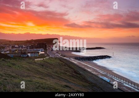 West Bay, Dorset, UK.  14th February 2020. UK Weather.  A red sky at dawn on valentines day shortly before sunrise at West Bay in Dorset ahead of the forecast bad weather from Storm Dennis.  Picture Credit: Graham Hunt/Alamy Live News Stock Photo