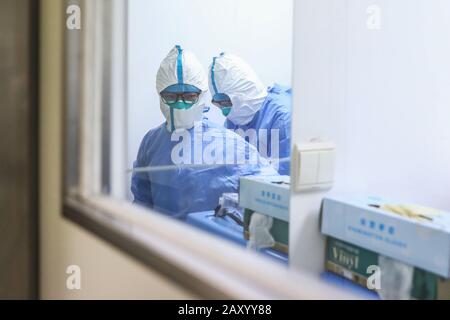 Beijing, China. 13th Feb, 2020. Pang Zhen (R) helps Chen Meiru to tighten her protective suit in the hospital in Beijing, capital of China, Feb. 13, 2020. Pang Zhen and Chen Meiru, a married couple, both work as nurses at intensive care unit of Beijing Ditan Hospital affiliated to Capital Medical University. Their department, including 16 doctors and 61 nurses, began to receive COVID-19 patients since January. 'We're family after work and comrades in the battle against the epidemic. We will strive to win the battle,' said Pang Zhen. Credit: Zhang Yuwei/Xinhua/Alamy Live News Stock Photo