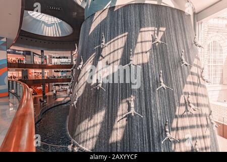 26 November 2019, UAE, Dubai: Famous fountain in Dubai Mall with flying men and waterfall Stock Photo