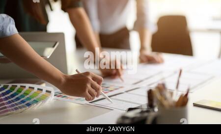 Close up view of professional UI developer team consulting on their project with digital tablet in meeting room Stock Photo