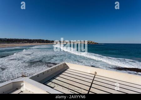 The empty Bondi Icebergs during a pool cleaning day. The contrast of the white empty pool with the blue ocean and textured dark rocks was appealing to Stock Photo