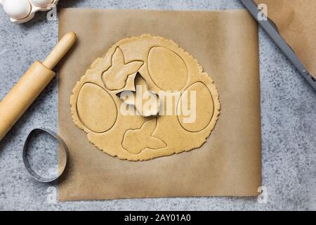 Process of making homemade cookies in shape of bunny and eggs on grey stone table. View from above. Easter. Stock Photo